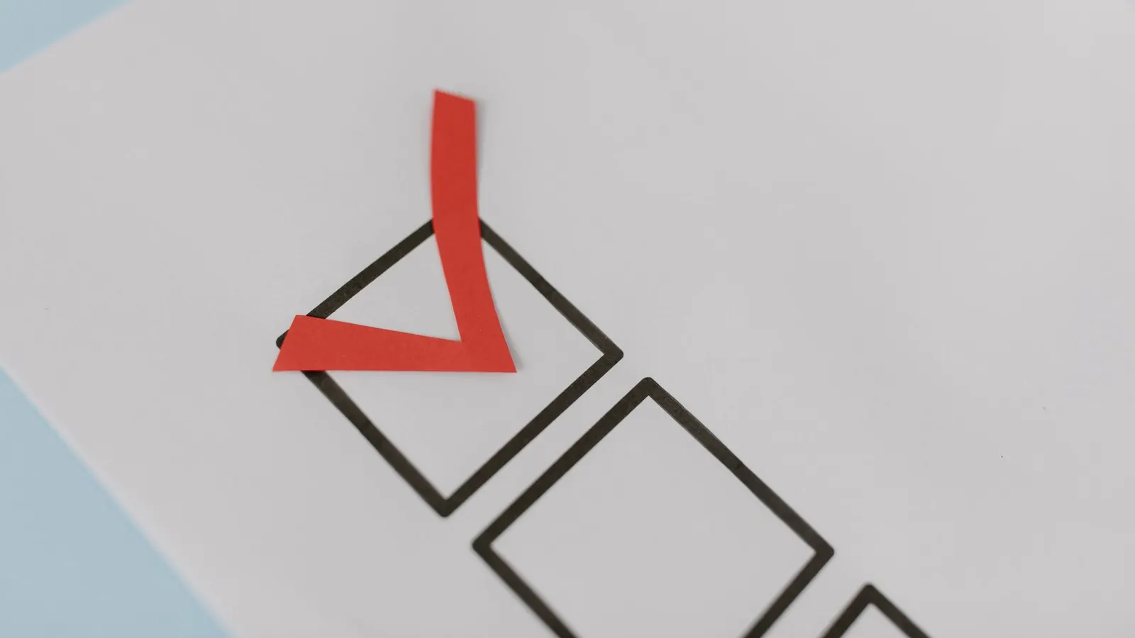 A printed checklist with empty black tick boxes and a single red check mark in one of them