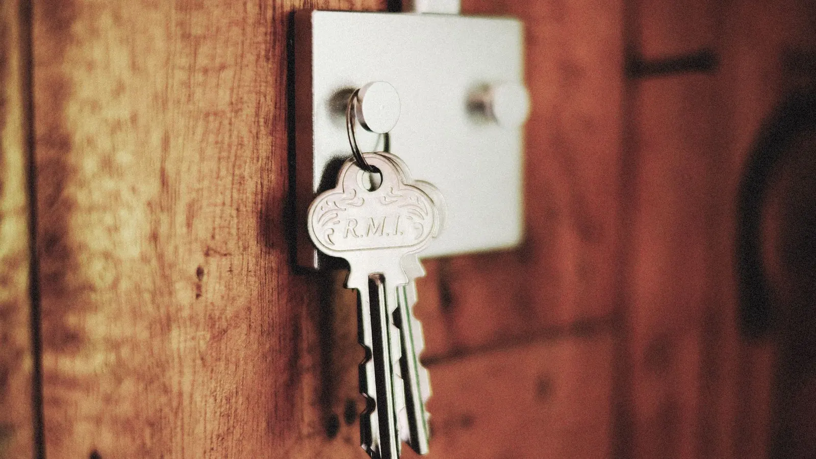 A bunch of keys left hanging from the lock of a wooden door